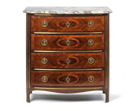 Commode de style Régence en placage de bois satiné et de palissandre à façade arrondi ouvrant par 4 tiroirs montants à cannel
