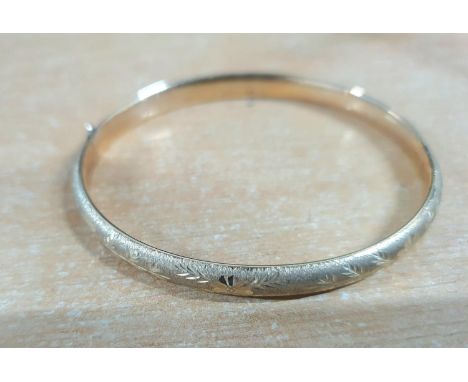 9ct yellow gold bangle with push button release clasp, partial engraved decoration,6.5 grams 