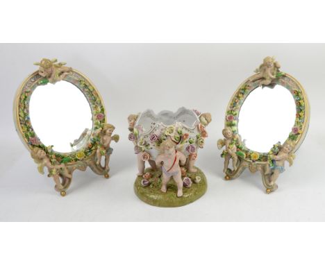 20th century Continental porcelain flower encrusted bowl supported by three cherubic figures on a naturalistic base, blue cro