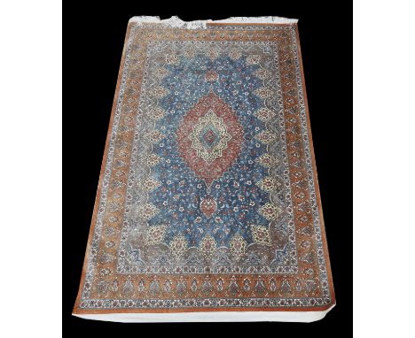 Persian silk rug, with a central floral medallion and floral motifs on a light blue ground, within floral border, 197 x 130cm