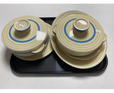 A tray of five pieces of Clarice Cliff Newport pottery dinner ware to include two lidded tureens, dinner plate and two meat p