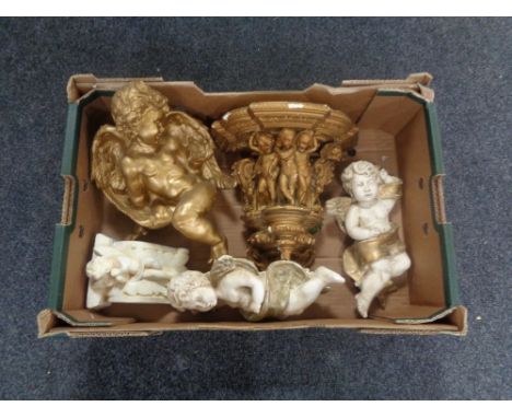 A box containing a gilt painted chalk cherub wall shelf together with four further cherub figures.  