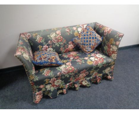 An early 20th century settee upholstered in a floral fabric together with two scatter cushions 