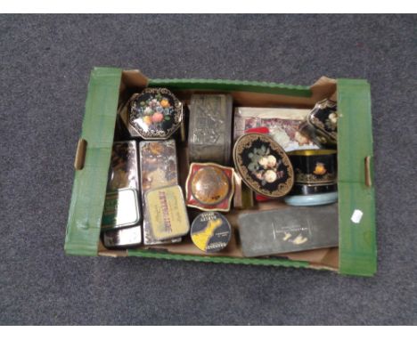 A box containing a collection of vintage tins.  