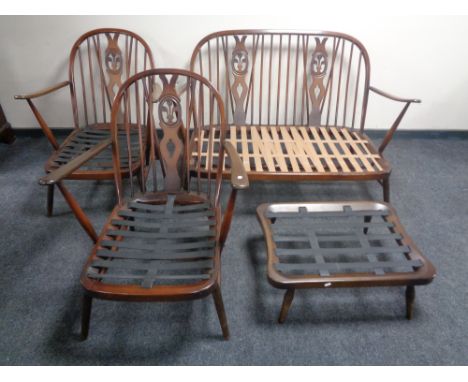 A four piece Ercol elm and beech lounge suite in an antique finish comprising of two seater settee, two armchairs and a foots