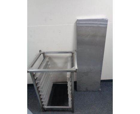 A stainless steel commercial tray stand together with a stainless steel shelf.  