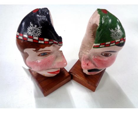 An unusual pair of hand painted shells mounted on wooden plinths, height 15 cm. (2)