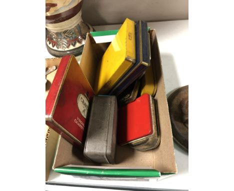 A box containing a collection of vintage cigarette and cigar tins.  