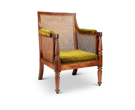 A Regency mahogany bergère chair attributed to GillowsThe rectangular caned back, padded arms and seat on ring turned taperin