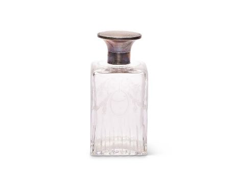 An Edwardian silver topped toilet water bottle
The hinged silver lid engraved with scales and a foliate border, the rectangul