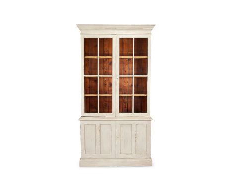 A Victorian later light grey painted bookcase cabinet
The rectangular ogee moulded cornice above a pair of astragal glazed do