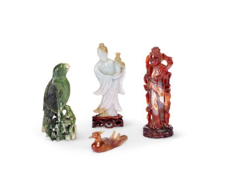 A celadon jade figure of a deity and three other figuresThe celadon jade figure of a deity holding a vase, an agate figure of