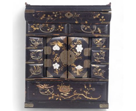 A Chinese black lacquered table-top jewellery/writing cabinet, the rising lid revealing a fitted interior with drawers, cupbo