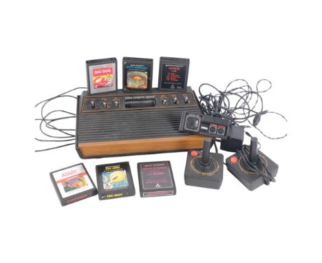 A Vintage Atari 2600 computer games console, with various power cables and joystick controllers, a quantity of associated Ata