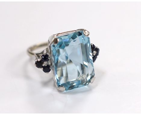 An 18ct white metal and single stone emerald cut aquamarines set dress ring, with six stone sapphire set shoulders, size L, g