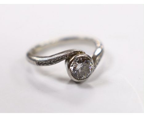 A modern platinum and collet set single stone diamond ring with diamond chip set crossover shoulders, size K, gross weight 5.