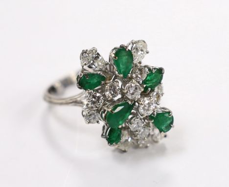 A modern white metal emerald and diamond cluster set dress ring, size R/S, the shank with two sizing spheres, gross weight 8 