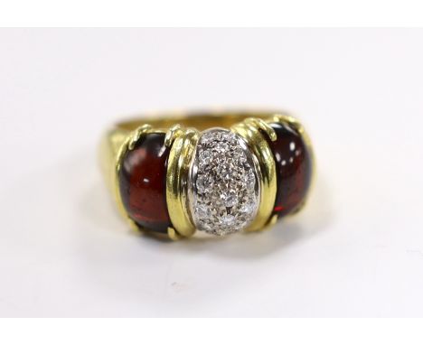 A modern 750 yellow metal and diamond cluster set dress ring, with two stone cabochon garnet set shoulders, size Q, gross wei