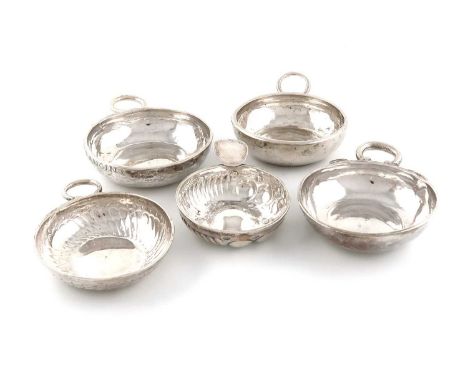 A collection of five French silver wine tasters,comprising: an 18th century one, with worn marks, circular form, snake ring h