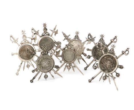 A collection of seven Maltese silver menu card holders,the centres are set with a coin, mounted with arms, cannons and Maltes