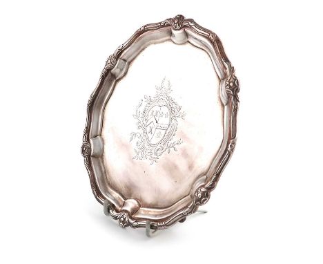 A George II silver waiter, by Paul de Lamerie, London 1744, circular form, foliate and scroll border, the centre with an armo