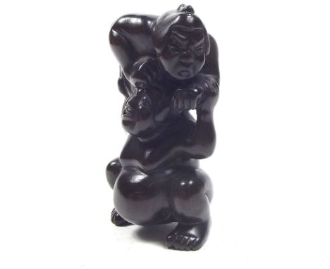 A Japanese carved wooden netsuke in the form of sumo wrestler