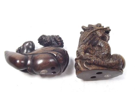 Two carved wood Japanese netsuke in the form of two toads on a gourd and a dragon