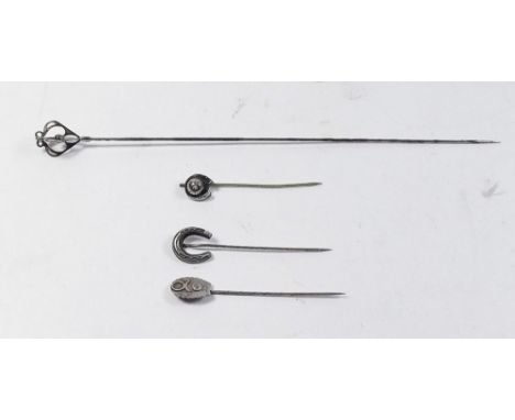 A silver hat pin and three stick pins 