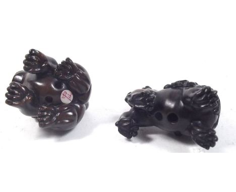 Two carved Japanese netsuke in the form of a dog and a Kylin lion