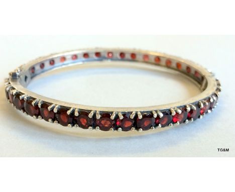 A silver and garnet set bangle