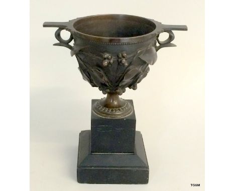 A Victorian bronze urn on a black marble base. 21cm tall