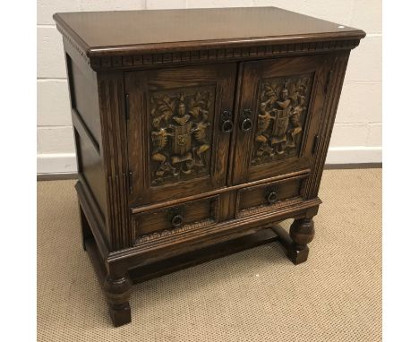 A 20th Century oak dwarf cupboard in the 17th Century manner, the plain top above two armorial carved doors enclosing a shelf