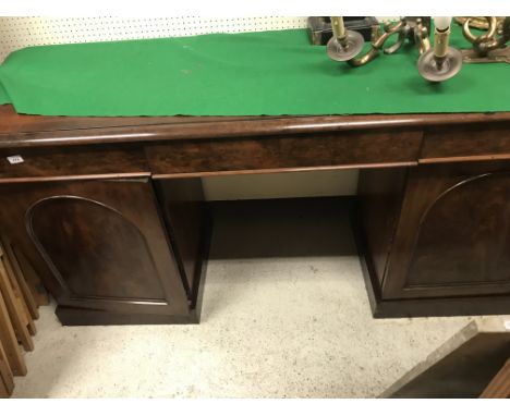 A Victorian mahogany sideboard, the plain top with moulded edge above three frieze drawers, raised on two pedestals with arch