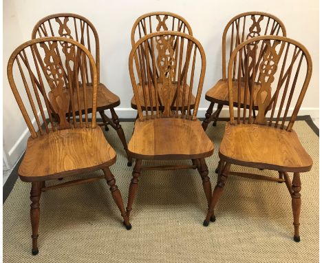 A set of six modern oak wheel and stick-back dining chairs