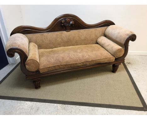 A Victorian mahogany framed scroll arm sofa, the show frame with fruit and floral carved back raised on turned and reeded sup