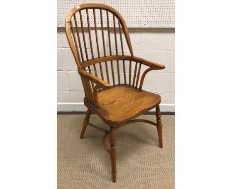 A modern oak Thames Valley style stick back elbow chair with shaped seat on turned supports united by a crinoline stretcher, 