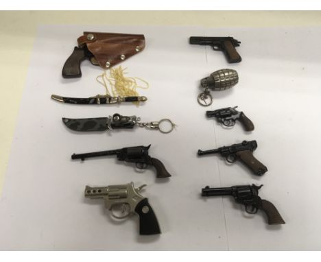 A collection of miniature weapons to include pistols and swords with scabbards. Also incljddd is a novelty pistol lighter and