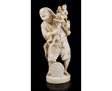 A JAPANESE OKIMONO OF A PUPPETEER MEIJI PERIOD (1868-1912) carved and with stained detail as a barefoot Bunraku artist holdin