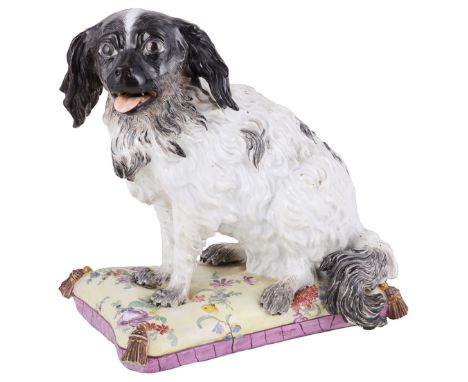 A MEISSEN FIGURE OF A SPANIEL  LATE 18TH CENTURY the black and white animal modelled seated with open mouth  on a yellow cush