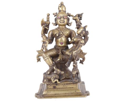 A BRASS SHRINE DEPICTING UMAMAHESVARA WESTERN INDIA CIRCA 18TH CENTURY on square plinth the four-armed god Siva seated on a r