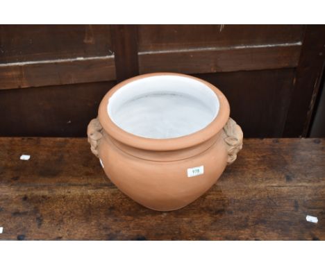 A terrracotta planter having glazed interior and mask handles