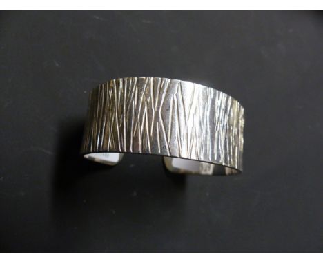 A GUILD OF HANDICRAFT SILVER BANGLE WITH BARK EFFECT FINISH. LONDON 2005. 2.2 OZS