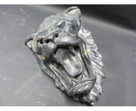 A CAST IRON DOOR KNOCKER IN THE UNUSUAL FORM OF A LION MASK