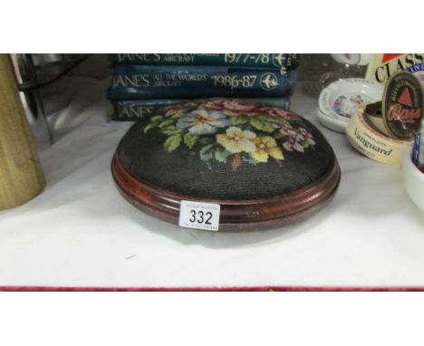 A Victorian style button footstool with floral tapestry top