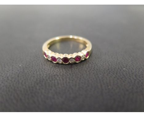 An 18ct gold ruby and diamond nine-stone ring - To the scalloped edge and plain band - Hallmarked London - Ring size O - Weig