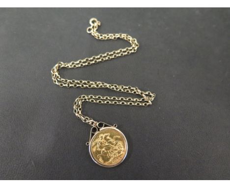 A George V 1918 sovereign coin - Mounted in a plain 9ct gold surround - Suspended from a 9ct gold belcher-link chain - Hallma