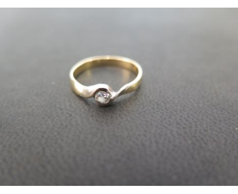 A diamond crossover style ring - The brilliant-cut diamond to the asymmetric shoulders - Stamped 750 - Ring size K - Weight a