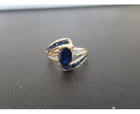 A 9ct gold sapphire and diamond crossover style dress ring - Hallmarked Birmingham - Ring size K 1/2 - Weight approx 2.8gms
C