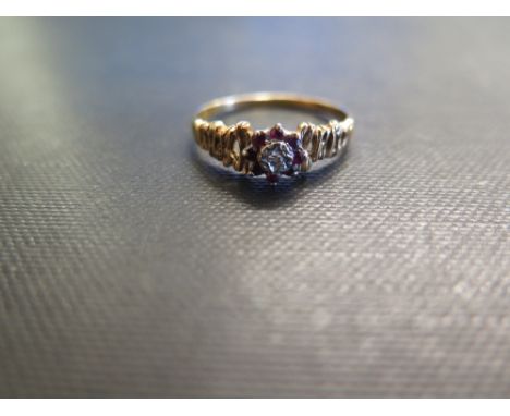 A ruby and diamond cluster ring - To the openwork textured shoulders - Stamped 18ct - Ring size U - Weight approx 3.6gms
Cond