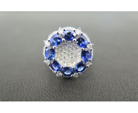 A sapphire and diamond cluster dress ring - The oval-shape sapphire circle to the pave-set diamond surmount - Stamped 18K - T